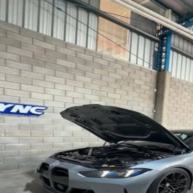 BMW M3 G80 with the hood open in the workshop